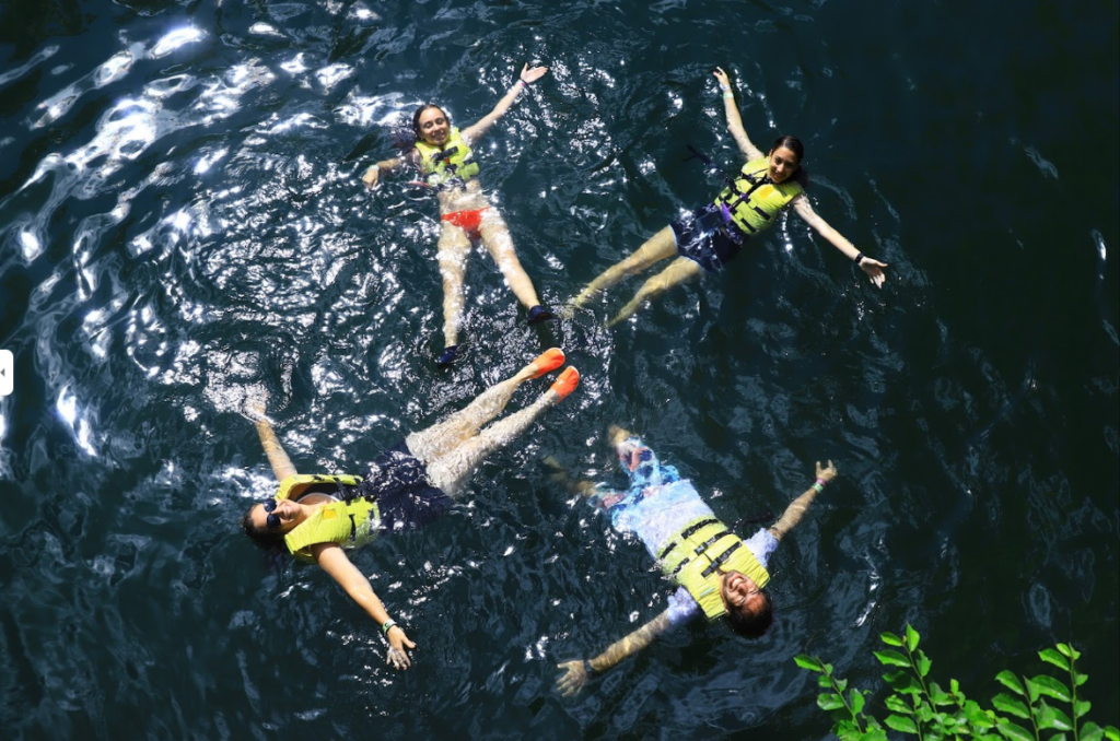 personas nadando en un cenote en la riviera maya
