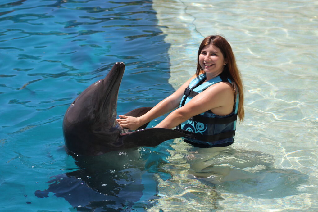 Turista realizando un Nado con Delfines en Cancún.